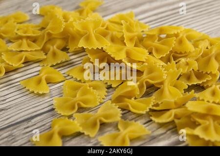 Penne Pasta versando dalla scatola sul tavolo di legno. Viste dall'alto Foto Stock