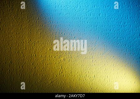 Su uno sfondo testurizzato, la fusione di giallo e blu Foto Stock
