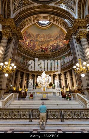 L'uomo inginocchiato alla modifica di L'Eglise Sainte-Marie-Madeleine - o la chiesa di Madeleine, Parigi, Ile-de-France, Francia Foto Stock