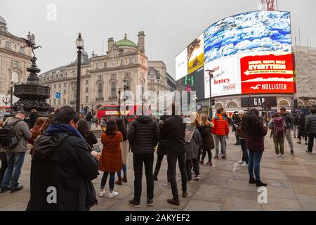 Londra, Regno Unito - 31 dicembre 2019: Alcune persone ascoltano un autobus a Piccadilly Circus Foto Stock