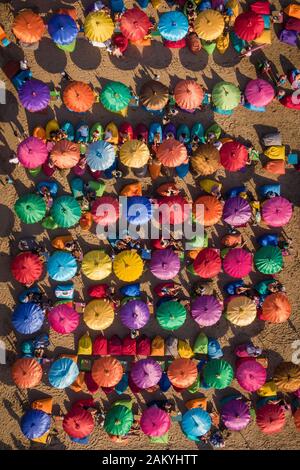 Vista aerea dall'alto dei colorati ombrelloni della famosa spiaggia di Seminyak a Bali, Indonesia. Foto Stock