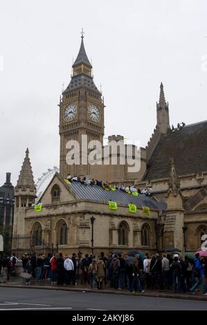 Greenpeace cambiamento climatico i manifestanti dimostrare sul tetto presso le Case del Parlamento europeo a Londra. Foto Stock