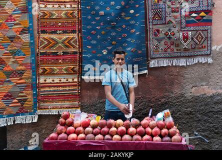 Giovani boyb vendita di succo di melograno in Marrakech Foto Stock