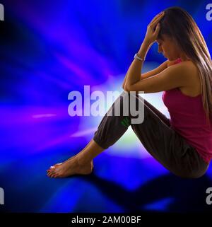 Donna seduta con testa in mano Foto Stock