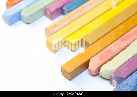 Pastelli colorati su sfondo bianco. Foto Stock