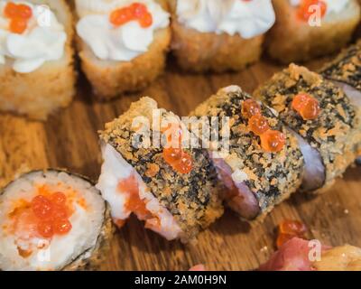 Involtini appetitosi su un piatto di legno nel ristorante DI RISO Foto Stock