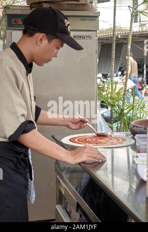 Pizzaiolo preparare la pizza in un ristorante di cucina Foto Stock