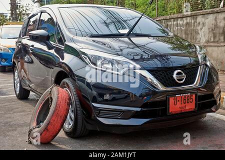 Veicolo bloccato per parcheggio illegale dal contraente privato utilizzando pneumatici vettura. Thailandia del sud-est asiatico Foto Stock