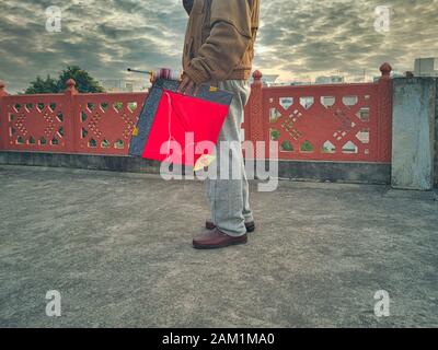 Jaipur, Rajasthan circa 2020 - Fotografia di un uomo che tiene un aquilone nella sua mano sinistra sul tetto di una casa. La fotografia è presa su una bella wint Foto Stock