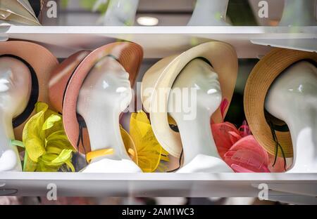 Una vetrina per la vendita e dimostrazione di diversi cappelli in feltro, sintetici e naturali, indossati sulle teste dei manichini, esposti in file di gabinetto Foto Stock