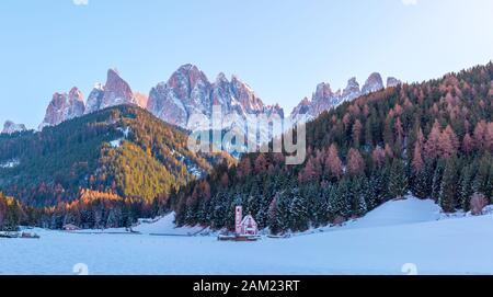 Vista sulla piccola chiesa di San Giovanni in Ranui e sulle montagne delle Dolomiti. Val di Funes. Italia, Alto Adige. Europa Foto Stock