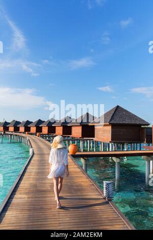 Donna presso le Ville Overwater a Olhuveli Beach and Spa Resort South Male Atoll, Kaafu Atoll, Maldive Foto Stock