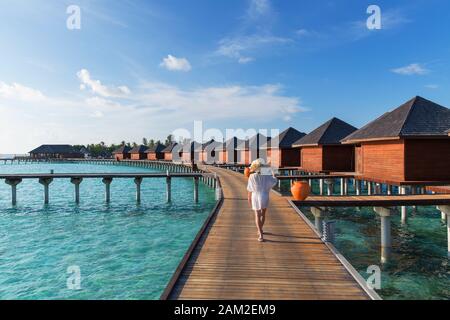 Donna presso le Ville Overwater a Olhuveli Beach and Spa Resort South Male Atoll, Kaafu Atoll, Maldive Foto Stock