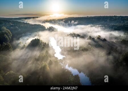 Splendida la nebbia oltre il fiume di sunrise, vista aerea Foto Stock