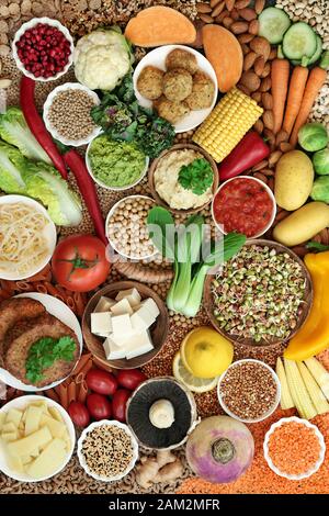 Sana collezione vegana super food con frutta, verdure, noci, spezie, cereali, tofu, falafel e hamburger realizzati con sostituto della carne. Mangiare etico. Foto Stock