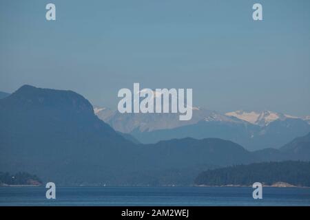 Montagne viste attraverso il mare calmo da Vancouver Island, British Columbia, Canada Foto Stock