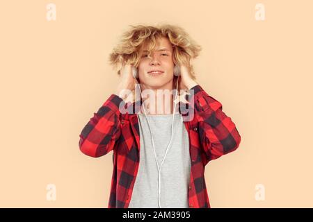 Giovane ragazzo adulto che ascolta musica in cuffie Foto Stock