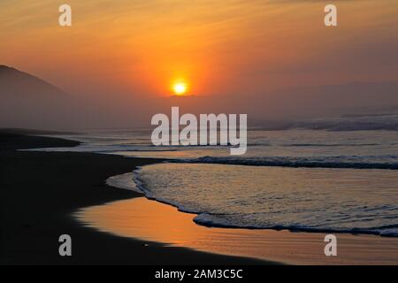 Seascape a sunrise e con colori caldi e riflessi dalla mattina presto sun, Sud Africa Foto Stock