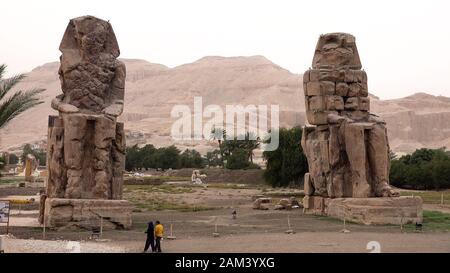 I Colossi di Memnon sono due imponenti statue di pietra del faraone Amenhotep III Dal 1350 a.C., si trovano nella Necropoli di Tebano, ci ha localizzato Foto Stock