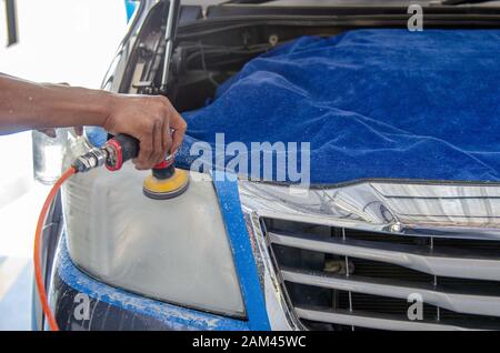 Mechanic la mano di lucidatura è la vettura del faro. Foto Stock