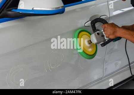 L'uomo mani tenendo l'attrezzo di lavoro polacco la vettura.Pulitura e lucidatura auto. Dettagli auto. Foto Stock