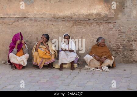 Villaggio locale womens seduto e chattare in un mercato in vrindavan, Uttarpradesh, India, Asia Foto Stock