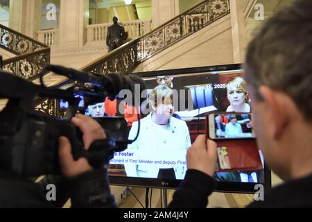 Ritrasmesso per correggere la didascalia giornalisti guarda un live feed su una televisione che mostra la elezione di Arlene Foster come Primo Ministro per la Northern Ireland Assembly presso gli edifici del Parlamento europeo, Stormont, Belfast, Irlanda del Nord, come la condivisione di potenza complessivo in Irlanda del Nord è stato ripristinato. Foto Stock