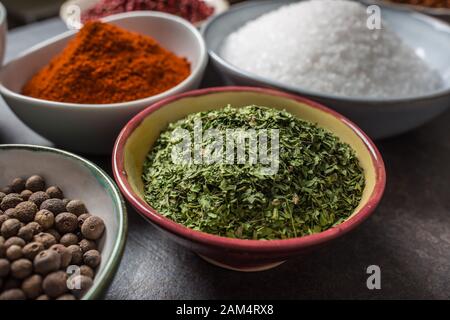 Prezzemolo essiccato e spezie varie ed erbe in ciotole Foto Stock