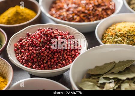 Pepe rosa e varietà di spezie ed erbe in ciotole Foto Stock
