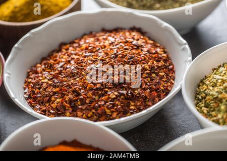 Peperoncino macinato e spezie di varietà e erbe in ciotole Foto Stock