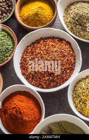 Peperoncino macinato e spezie di varietà e erbe in ciotole Foto Stock