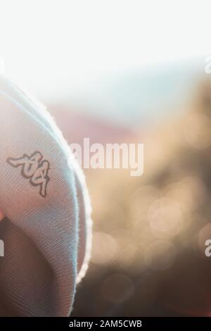 Primo piano di una Kappa beanie, logo della società chiaramente visibile con sfondo soffiata fuori con dure sun Foto Stock
