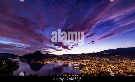 Bellissimo e colorato tramonto sulla città di Lugano da Aldesago Foto Stock