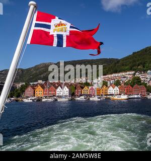 Il porto interno di Bergen, Norvegia. Vaagen, Maria Church, Bryggen con molte barche da diporto. Bandiera norvegese per le navi che trasportano posta ufficiale. Foto Stock