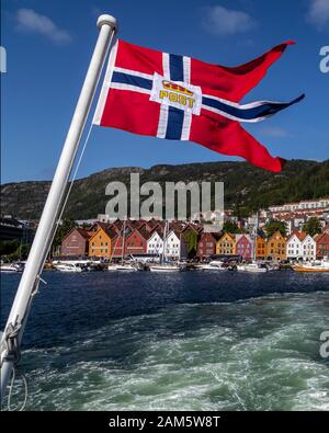 Il porto interno di Bergen, Norvegia. Vaagen, Maria Church, Bryggen con molte barche da diporto. Bandiera norvegese per le navi che trasportano posta ufficiale. Foto Stock