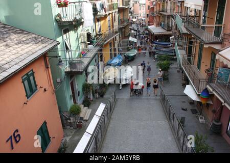 La cittadina ligure di Monterosso al Mare scende tra le rocce attraverso il tipico villaggio turistico tra le case colorate e i vari ristoranti Foto Stock