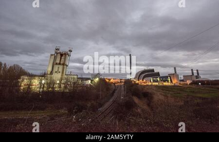 Colpo notturno industriale della moderna centrale elettrica Seabank a gas, Avonmouth UK, e di una vecchia fabbrica chimica di ruggine con una linea ferroviaria Foto Stock