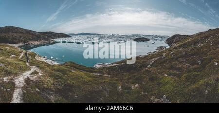 Panorama aereo di bellissimo paesaggio con iceberg galleggianti in laguna glaciale e lago in Groenlandia. Ghiacciaio Iluissat Icefjord. Iceberg e ghiaccio Foto Stock