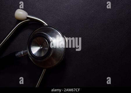 Primo piano Stetoscopio nero isolato su tavolo nero Foto Stock