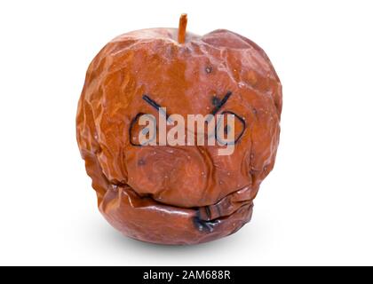 Melo marce con un volto, espressione di emozioni. Frutta su sfondo bianco. Una mela marrone, rovinata su cui un feltro-punta ha verniciato gli occhi ed un sorriso. Th Foto Stock