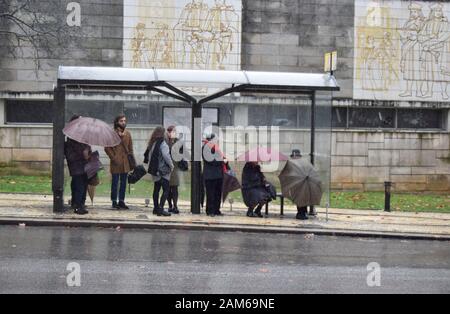 COIMBRA, PORTOGALLO - 04 gennaio 2016 - le persone cercano di rimanere asciutte durante le piogge intense nella Repubblica di Praca nel centro di Coimbra, Portogallo Foto Stock