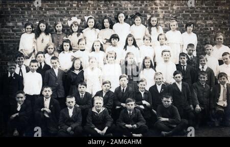 Un grande gruppo di fotografia in aula con 24 ragazze e ragazzi di 23 e 1 insegnante, c. 1915, STATI UNITI D'AMERICA. Foto Stock