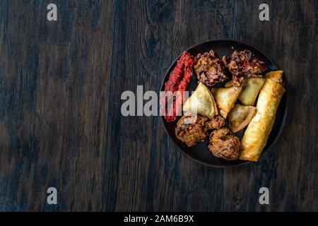 Il cibo indiano piastra con pollo, Pakora, Aloo Tikki, Samosas Samsa e involtini primavera. I cibi tradizionali. Foto Stock