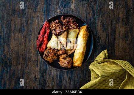 Il cibo indiano piastra con pollo, Pakora, Aloo Tikki, Samosas Samsa e involtini primavera. I cibi tradizionali. Foto Stock