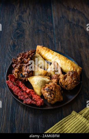 Il cibo indiano piastra con pollo, Pakora, Aloo Tikki, Samosas Samsa e involtini primavera. I cibi tradizionali. Foto Stock