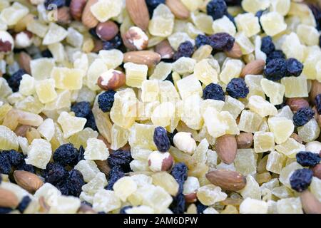Una miscela di frutta secca e noci per la granola. Uvetta, fette di ananas e mandorle vista dall'alto. Gustoso spuntino veloce per ripristinare l'energia. Foto Stock