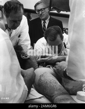 Autore Ray Bradbury (con gli occhiali) guardando ROD STEIGER con Make Up artisti della pittura di immagini tatuaggio al suo corpo produzione candida durante la ripresa dell'illustrato uomo 1969 regista Jack Smight prenota Ray Bradbury SKM / Warner Bros / Sette Arti Foto Stock