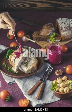 Donna condimento gustoso lievito di maiale lardo pancetta fatback con pepe nero e altre erbe e spezie in piatto di ceramica. Tradizionale Ucraino, Ungherese, Po Foto Stock