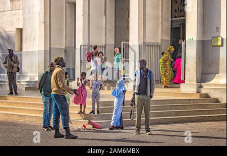 Dakar, Senegal - 24 aprile 2019: Famiglia senegalese in attesa di una chiesa di messa nella capitale Dakar, Senegal, Africa. Parlano insieme. Foto Stock