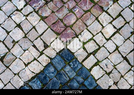 Close up portoghese di acciottolato in forme geometriche e dei colori Foto Stock